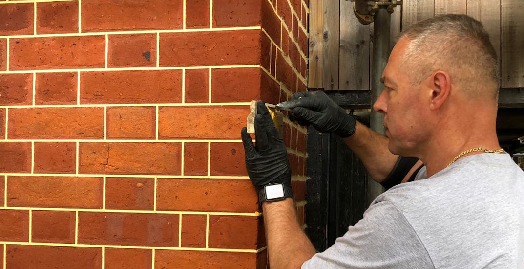 picture of a man doing a brick restoration repointing