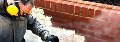 picture of a brick restoration contractor removing paint of the bricks using steam