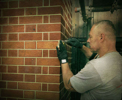 picture of a man doing a brick restoration repointing